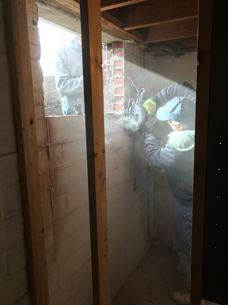 Cutting the wall with a massive saw.